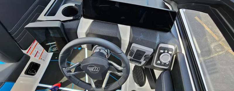 Slide: The Image of 2025 Malibu 25LSV boat dashboard with modern steering wheel and control panel. - 15