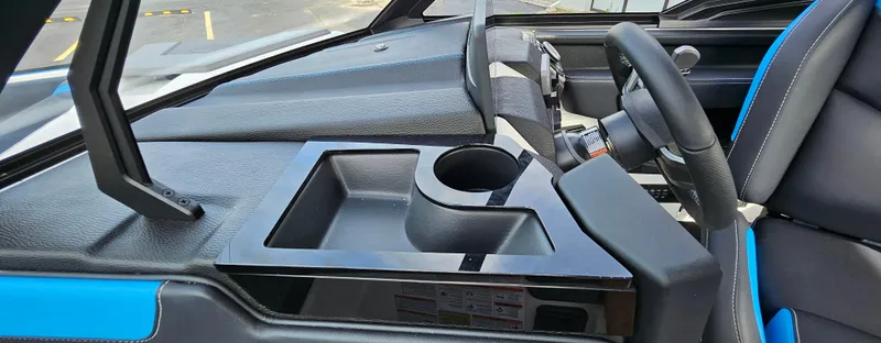 Slide: The Image of 2025 Malibu 25LSV boat interior with sleek dashboard and cup holder. - 16