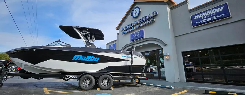 Slide: The Image of 2025 Malibu 25LSV boat displayed at Arrowhead Boat Sales dealership. - 2