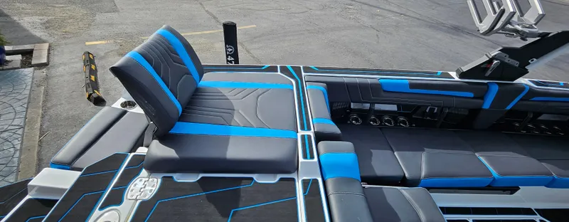 Slide: The Image of 2025 Malibu 25LSV boat interior with blue and gray seating, modern design. - 6