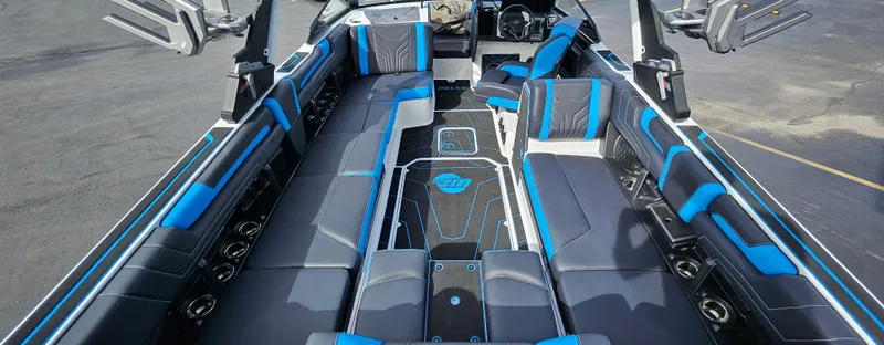 Slide: The Image of 2025 Malibu 25LSV boat interior with blue and black seating, spacious layout. - 9