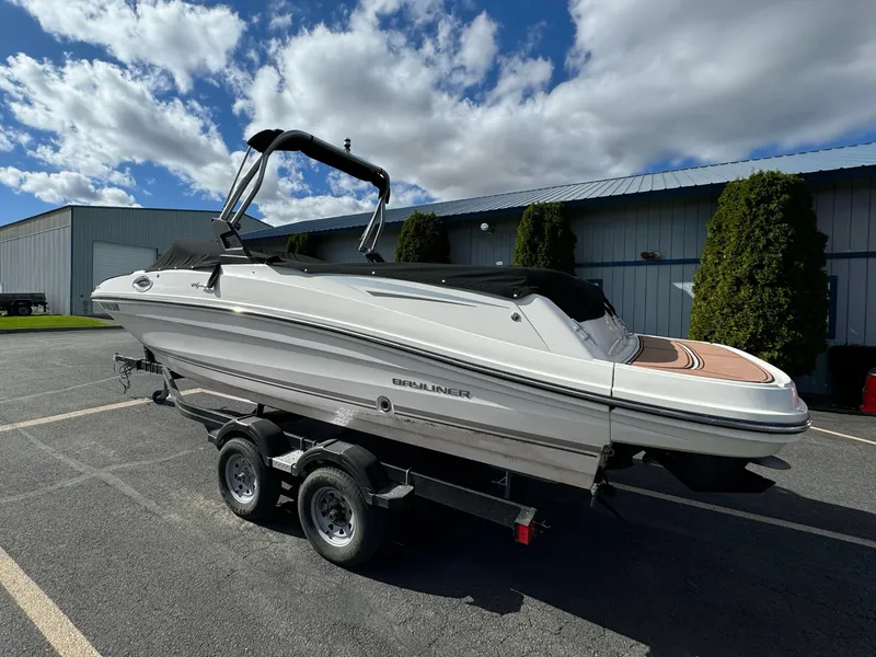 Slide: The Image of 2016 Bayliner VR6 boat on trailer, parked outdoors under a partly cloudy sky. - 11
