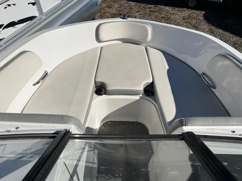 Slide: The Image of 2016 Bayliner VR6 boat interior with white cushioned seating and cup holders. - 16