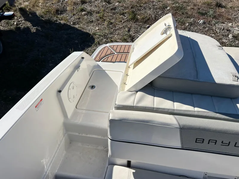 Slide: The Image of 2016 Bayliner VR6 boat interior with open storage compartment and cushioned seating. - 23