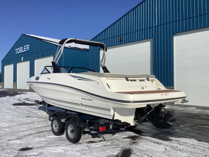 Slide: The Image of 2016 Bayliner VR6 boat on trailer, parked outside blue warehouse in snowy setting. - 8