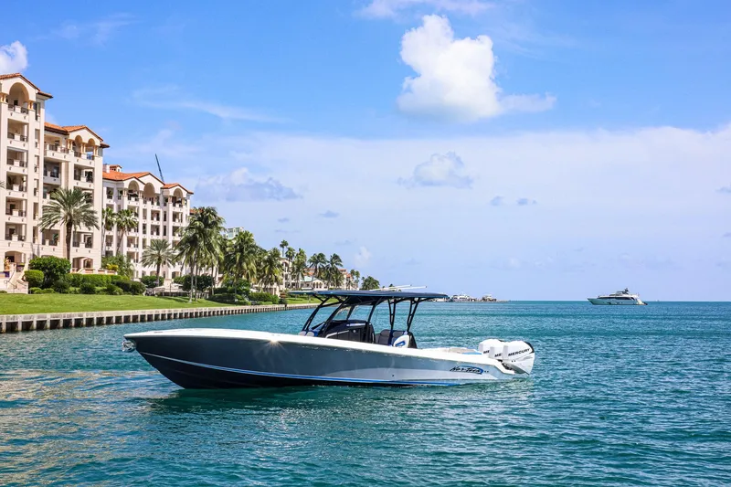 The Image of 2020 Nor-Tech 340 boat cruising near waterfront buildings under a clear blue sky. - 0