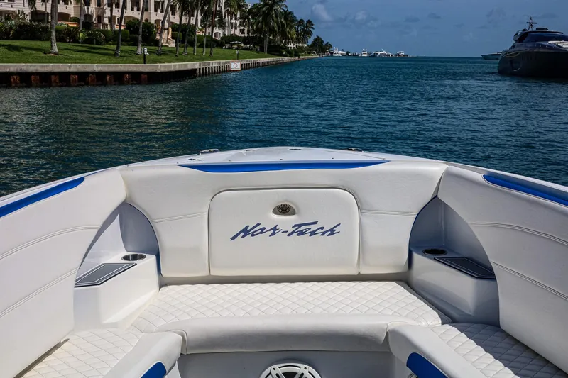 Slide: The Image of 2020 Nor-Tech 340 boat interior with waterfront view, featuring white and blue seating. - 11
