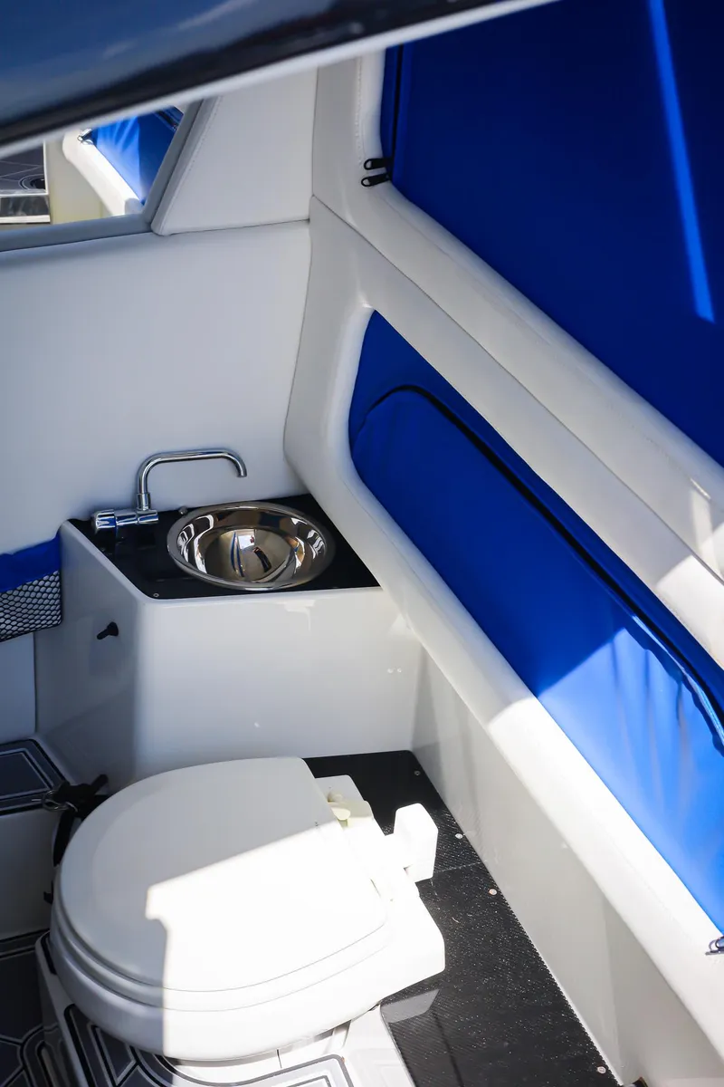 Slide: The Image of 2020 Nor-Tech 340 boat interior with toilet and sink, featuring blue accents. - 13