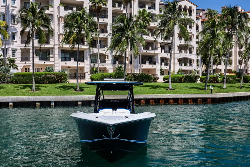 Slide: The Image of 2020 Nor-Tech 340 boat on water, with luxury apartments and palm trees in the background. - 3