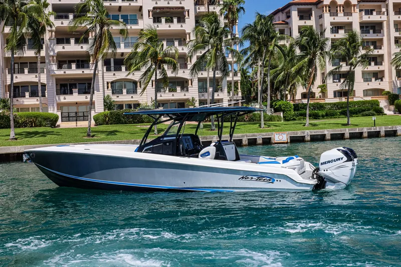 Slide: The Image of 2020 Nor-Tech 340 boat cruising near waterfront buildings and palm trees. - 4