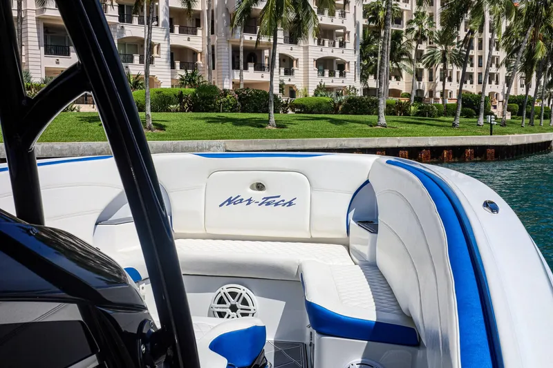 Slide: The Image of 2020 Nor-Tech 340 boat interior with white and blue seating, near waterfront buildings. - 7