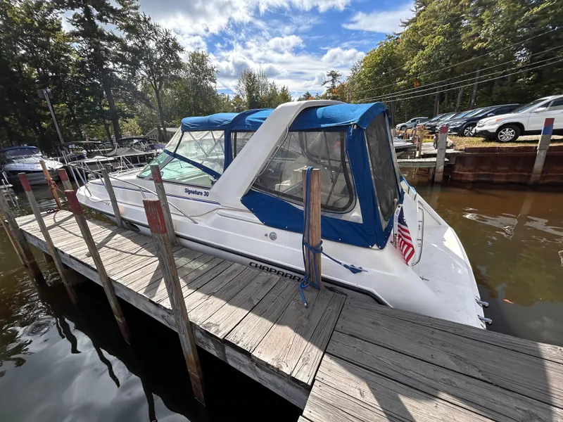 Slide: The Image of 1992 Chaparral Signature 30 boat docked, featuring blue canopy and American flag. - 10