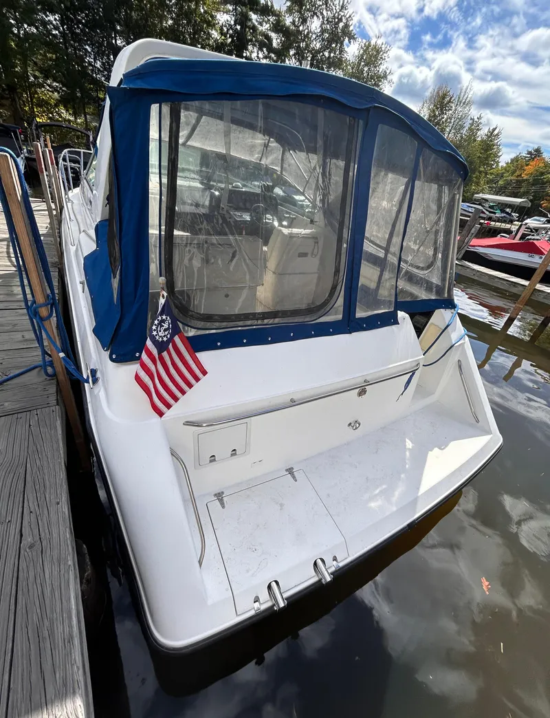 Slide: The Image of 1992 Chaparral Signature 30 boat docked, featuring blue canopy and American flag. - 11