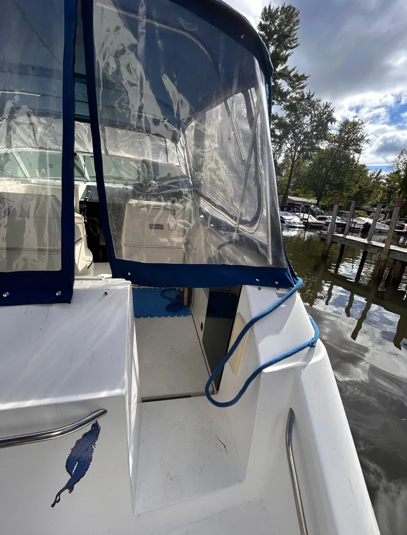 Slide: The Image of 1992 Chaparral Signature 30 boat docked, featuring blue trim and clear canopy. - 12