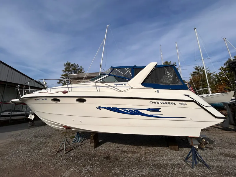 Slide: The Image of 1992 Chaparral Signature 30 boat on stands, white hull with blue accents, outdoor setting. - 13