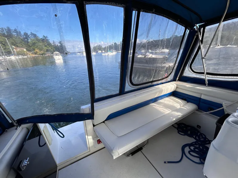 Slide: The Image of 1992 Chaparral Signature 30 boat interior with seating, docked in a scenic marina. - 16