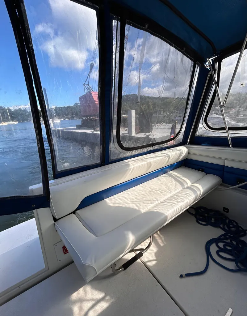 Slide: The Image of 1992 Chaparral Signature 30 boat interior with white seating and marina view. - 17