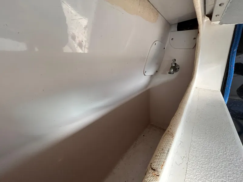 Slide: The Image of Interior compartment of a 1992 Chaparral Signature 30 boat, featuring white fiberglass and storage space. - 22