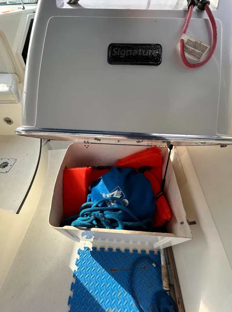 Slide: The Image of 1992 Chaparral Signature 30 boat storage compartment with life jackets and ropes. - 39