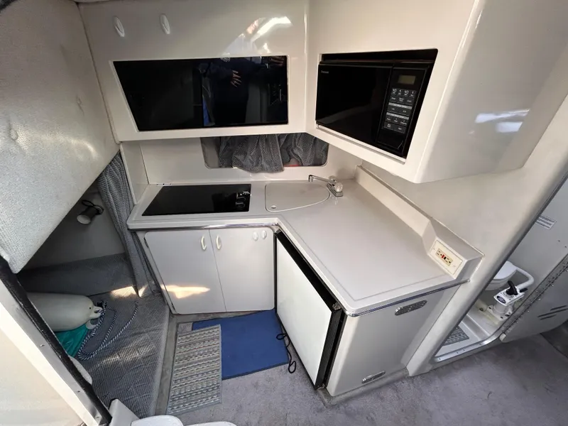 Slide: The Image of Interior of 1992 Chaparral Signature 30 boat kitchen with stove, sink, and refrigerator. - 44