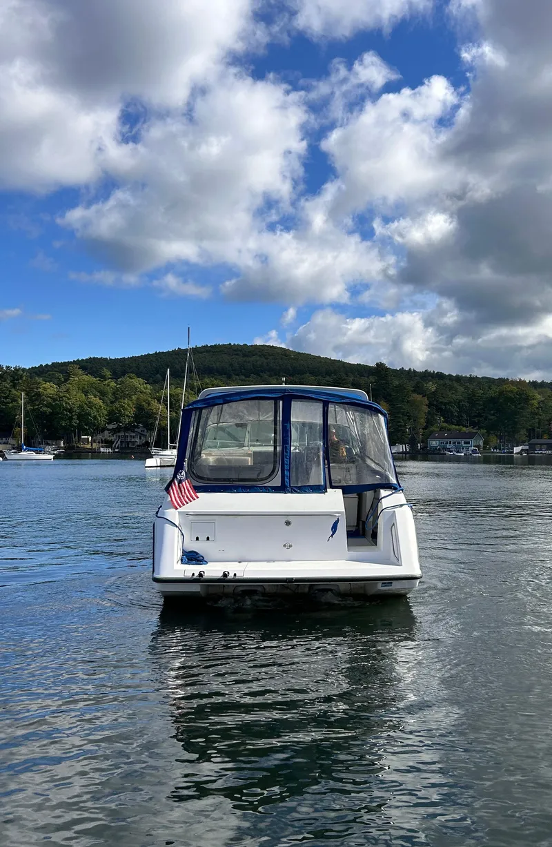 Slide: The Image of 1992 Chaparral Signature 30 boat on calm water, scenic background with clouds and trees. - 9