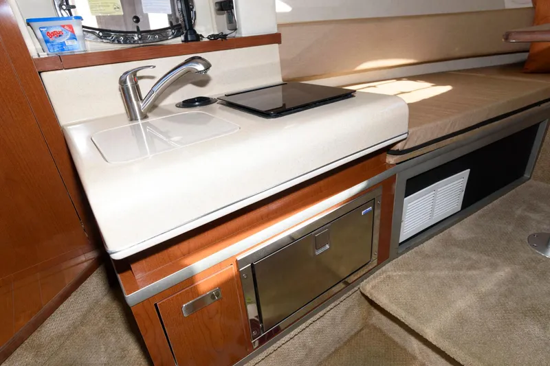 Slide: The Image of Interior of 2011 Sea Ray 260 Sundancer with kitchenette and seating area. - 11