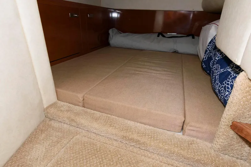Slide: The Image of Interior cabin of 2011 Sea Ray 260 Sundancer with beige cushions and wooden cabinetry. - 13
