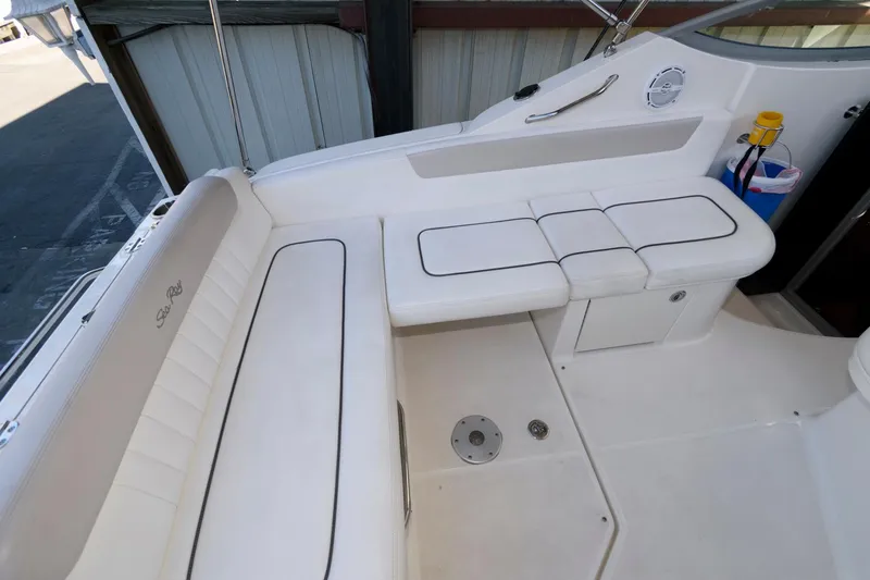 Slide: The Image of 2011 Sea Ray 260 Sundancer boat interior with white seating and storage compartments. - 3