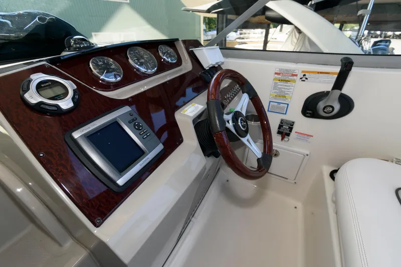 Slide: The Image of 2011 Sea Ray 260 Sundancer dashboard with steering wheel and navigation controls. - 7