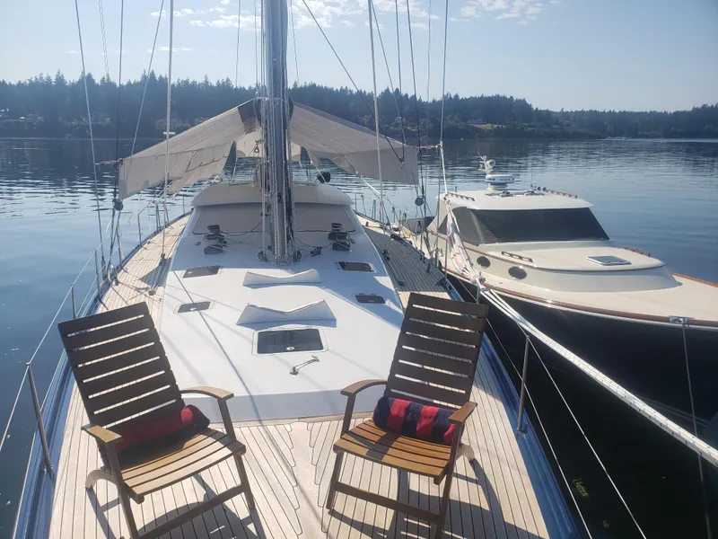 Slide: The Image of 2002 Northern Marine Pilothouse Sloop on calm water, featuring deck chairs and scenic background. - 23