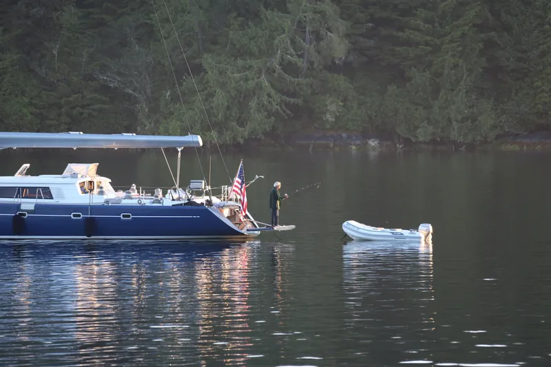 Slide: The Image of A 2002 Northern Marine Pilothouse Sloop anchored with a person fishing nearby. - 28