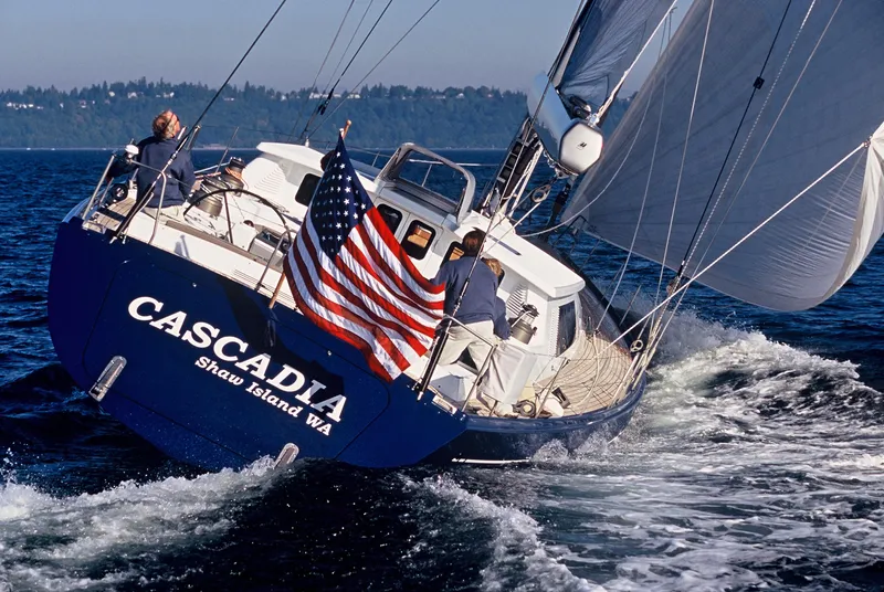 Slide: The Image of 2002 Northern Marine Pilothouse Sloop "Cascadia" sailing with American flag on open water. - 3
