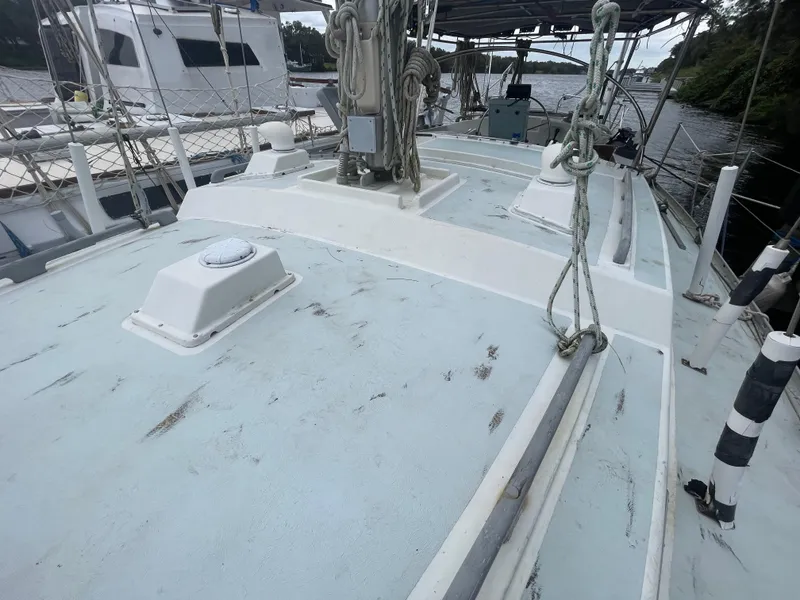 Slide: The Image of 1979 Moody 36 Classic sailboat deck with ropes and equipment, docked near other boats. - 14