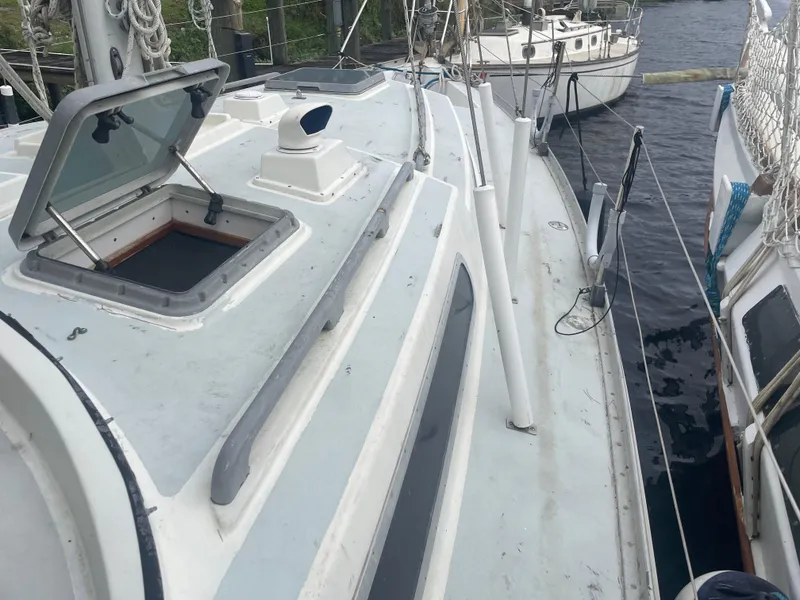 Slide: The Image of 1979 Moody 36 Classic sailboat deck with open hatch, docked alongside other boats. - 18