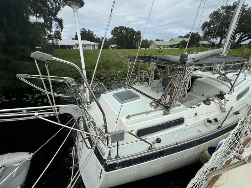 Slide: The Image of 1979 Moody 36 Classic sailboat docked by a grassy shoreline. - 21