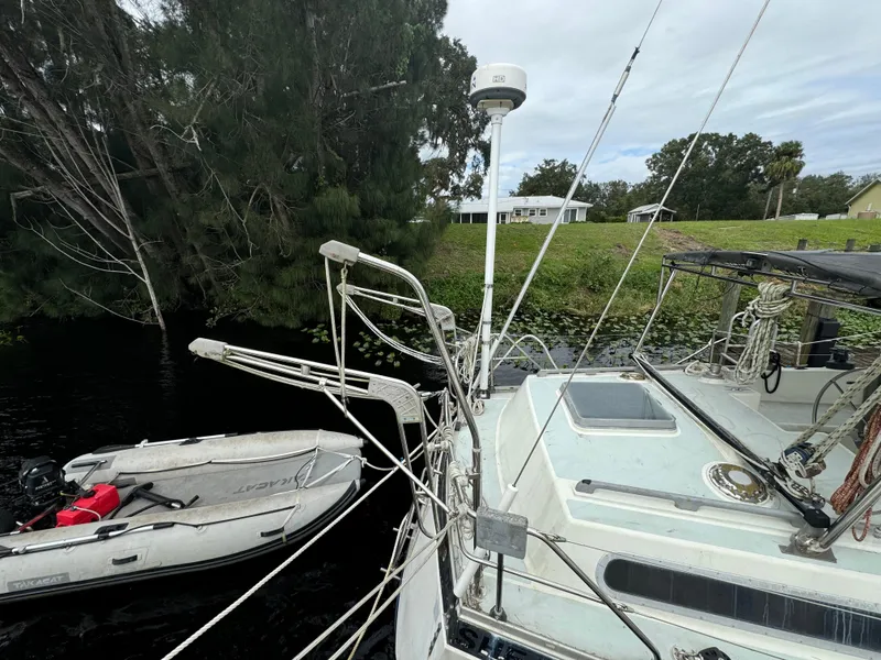 Slide: The Image of 1979 Moody 36 Classic sailboat docked near trees with inflatable dinghy. - 24