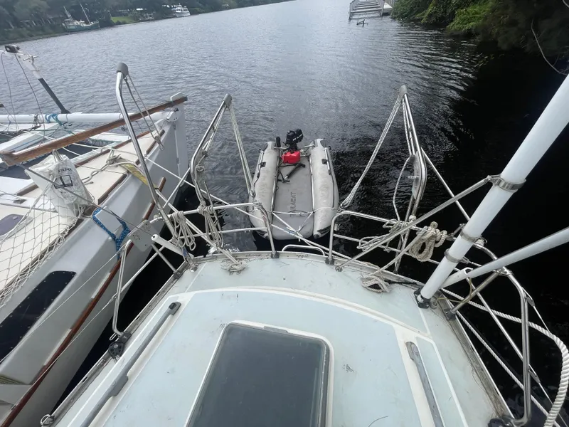 Slide: The Image of View from a 1979 Moody 36 Classic sailboat, docked beside another boat on a calm river. - 25