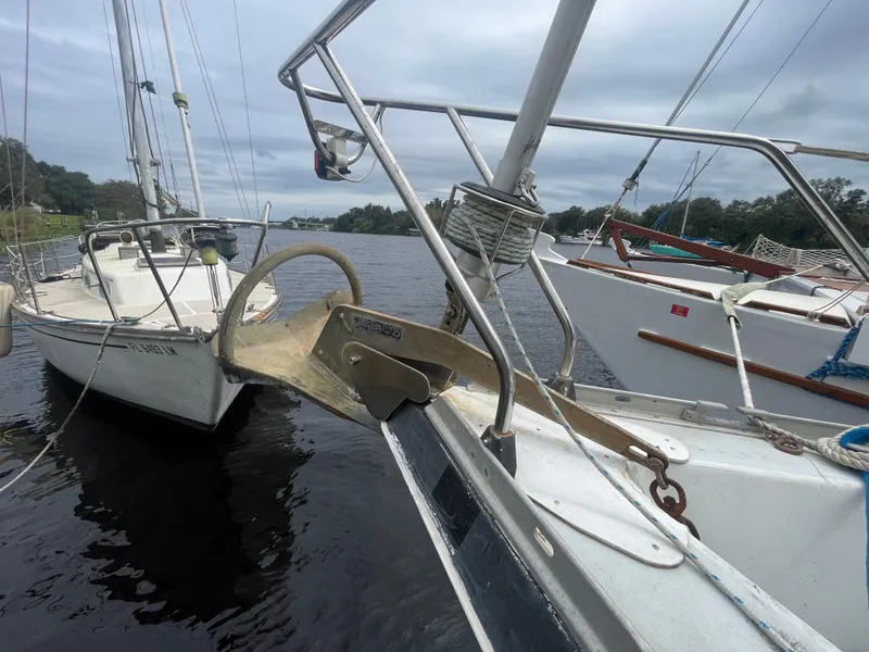 Slide: The Image of 1979 Moody 36 Classic sailboat anchored on a calm river under cloudy skies. - 3