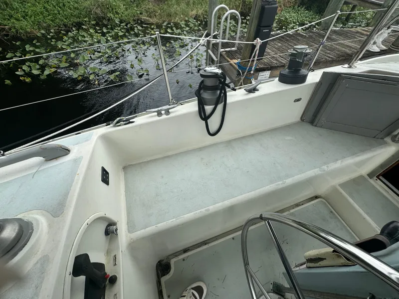 Slide: The Image of Cockpit of 1979 Moody 36 Classic sailboat near a dock with lush greenery. - 32