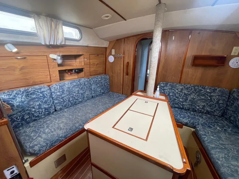 Slide: The Image of 1979 Moody 36 Classic yacht interior with wood paneling and blue patterned seating. - 36