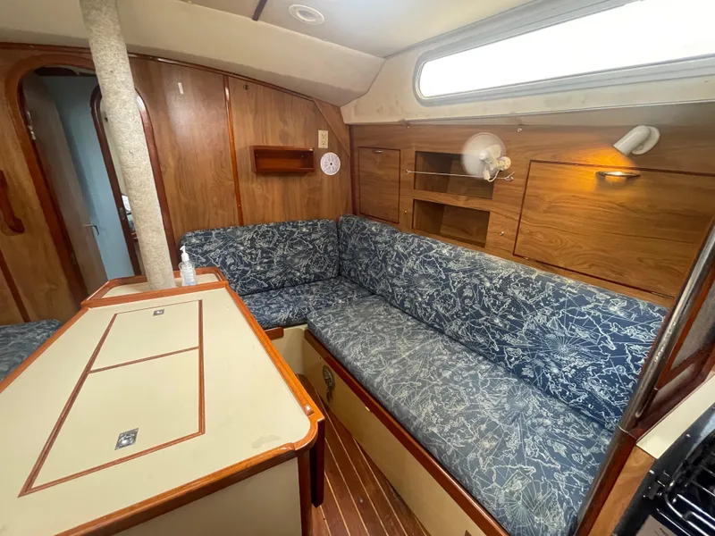 Slide: The Image of 1979 Moody 36 Classic yacht interior with wooden paneling and blue patterned seating. - 37