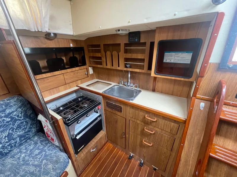 Slide: The Image of 1979 Moody 36 Classic yacht interior with wooden cabinetry and compact kitchen. - 40