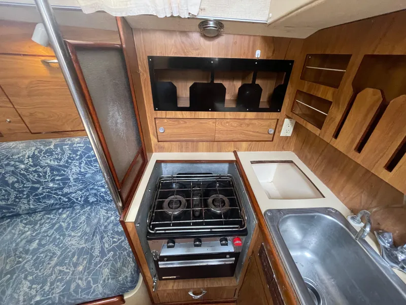 Slide: The Image of 1979 Moody 36 Classic yacht kitchen with stove, sink, and wooden cabinetry. - 42