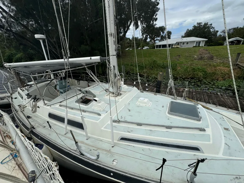 Slide: The Image of 1979 Moody 36 Classic sailboat docked near lush greenery. - 8