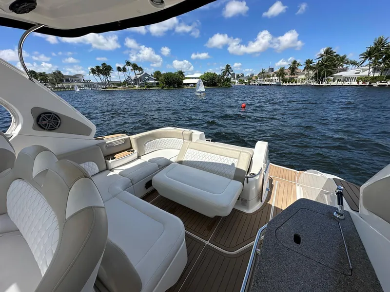 Slide: The Image of 2014 Chaparral 330 Signature boat interior with luxurious seating, overlooking scenic waterfront. - 1