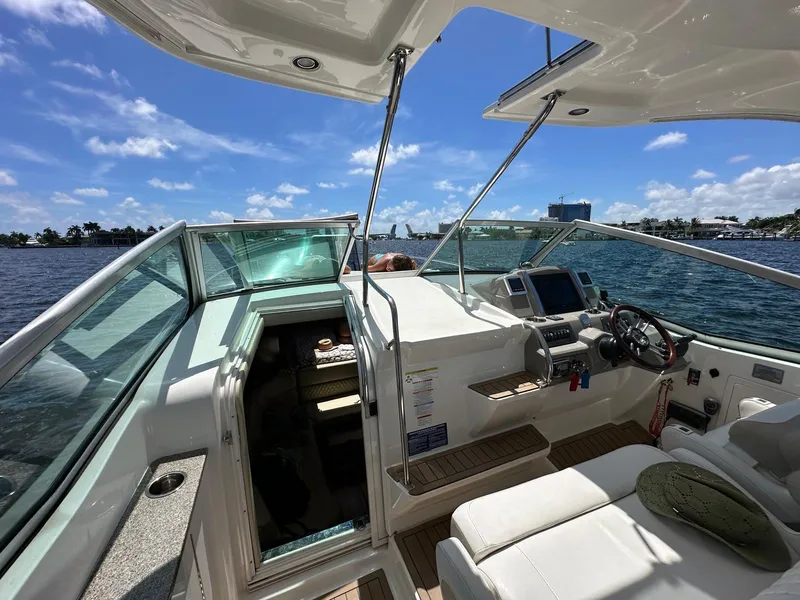 Slide: The Image of 2014 Chaparral 330 Signature boat interior with helm, seating, and open cabin door. - 3
