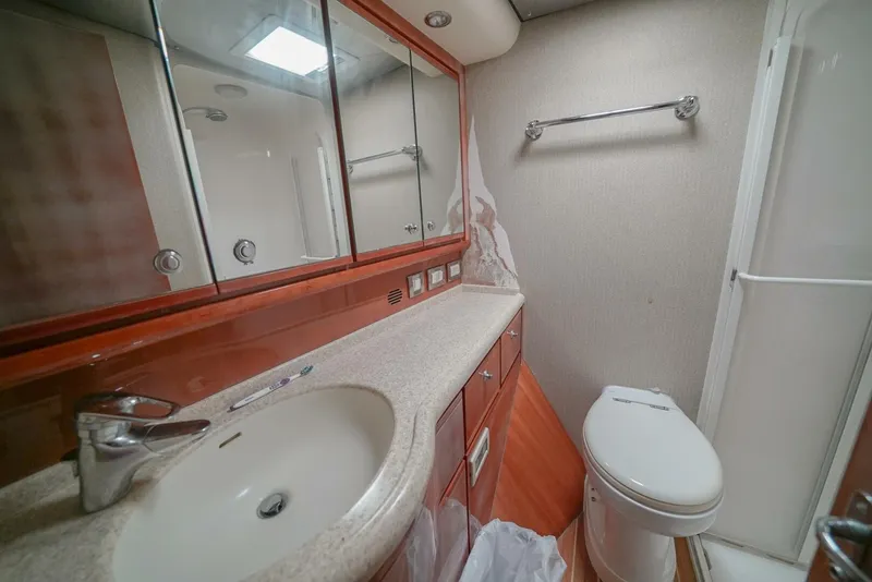 Slide: The Image of 2007 Bertram 510 Convertible yacht bathroom with sink, toilet, and mirrored cabinets. - 11