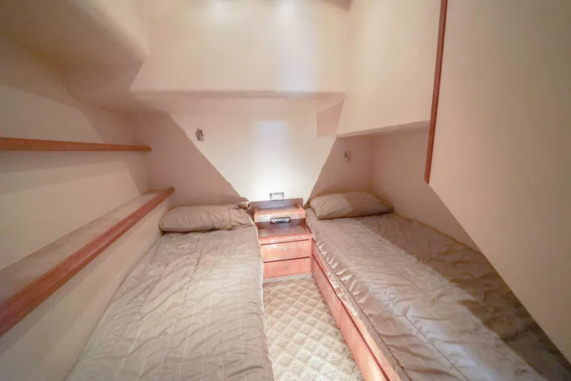 Slide: The Image of 2007 Bertram 510 Convertible cabin with twin beds and wooden accents. - 15