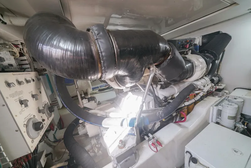 Slide: The Image of Engine room of a 2007 Bertram 510 Convertible yacht, showcasing complex machinery and components. - 24