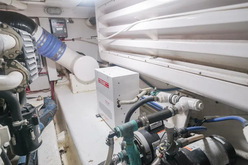 Slide: The Image of Engine room of 2007 Bertram 510 Convertible yacht, showcasing mechanical components and piping. - 27